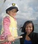 A woman and child on a boat in the ocean.