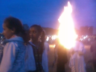 A crowd of people standing around a fire.